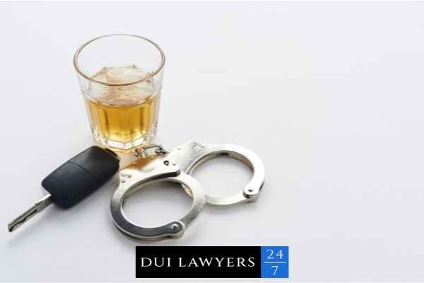 handcuffs, alcohol, and car keys on a white background